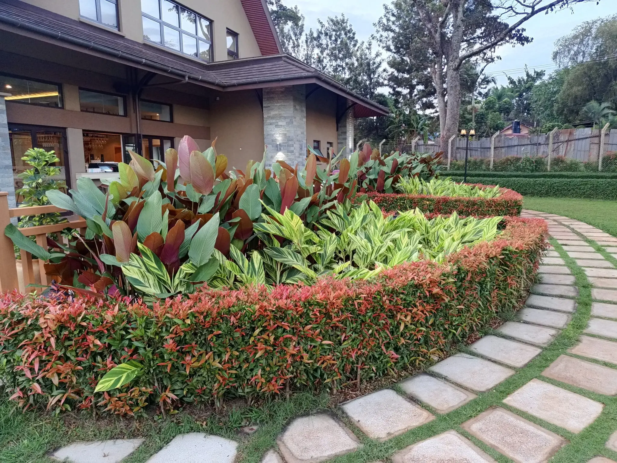 A planted bed and stone path beside mown turf