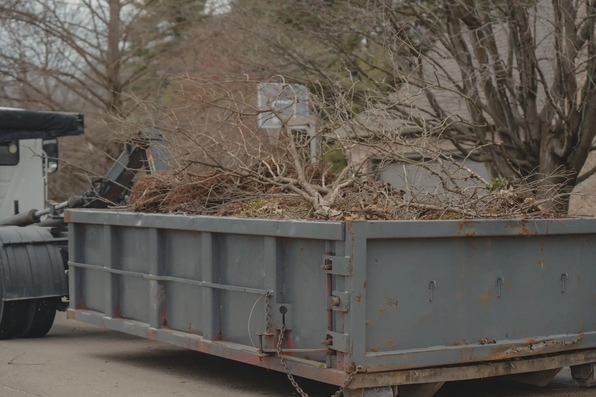 A dump trailer loaded with brush and branches from a cleanup