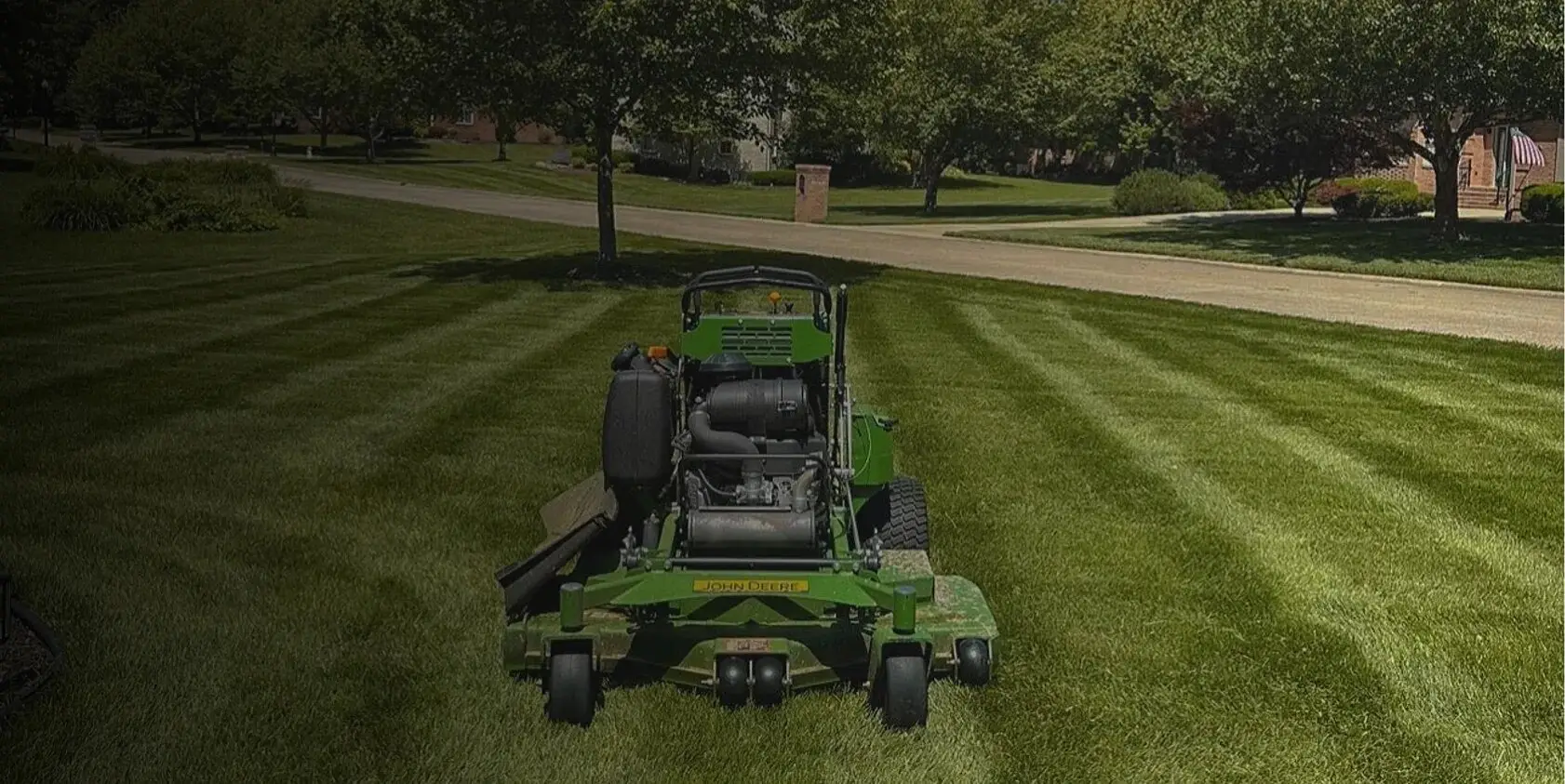A Royal Acres mower on a freshly striped lawn