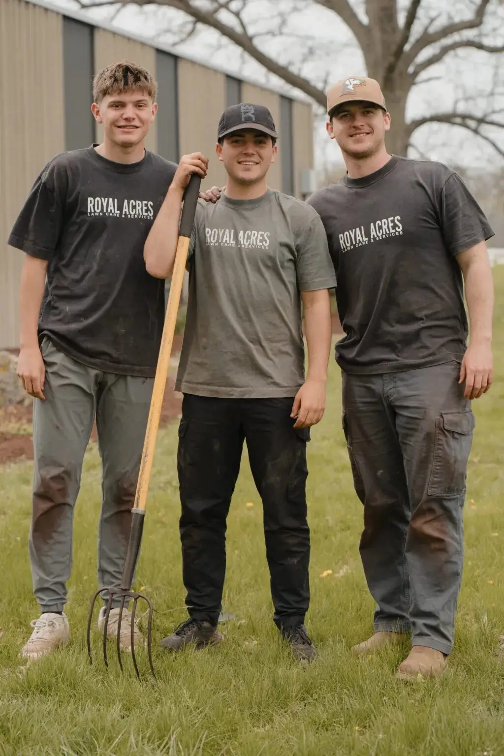 Three of the crew in company shirts, one holding a pitchfork