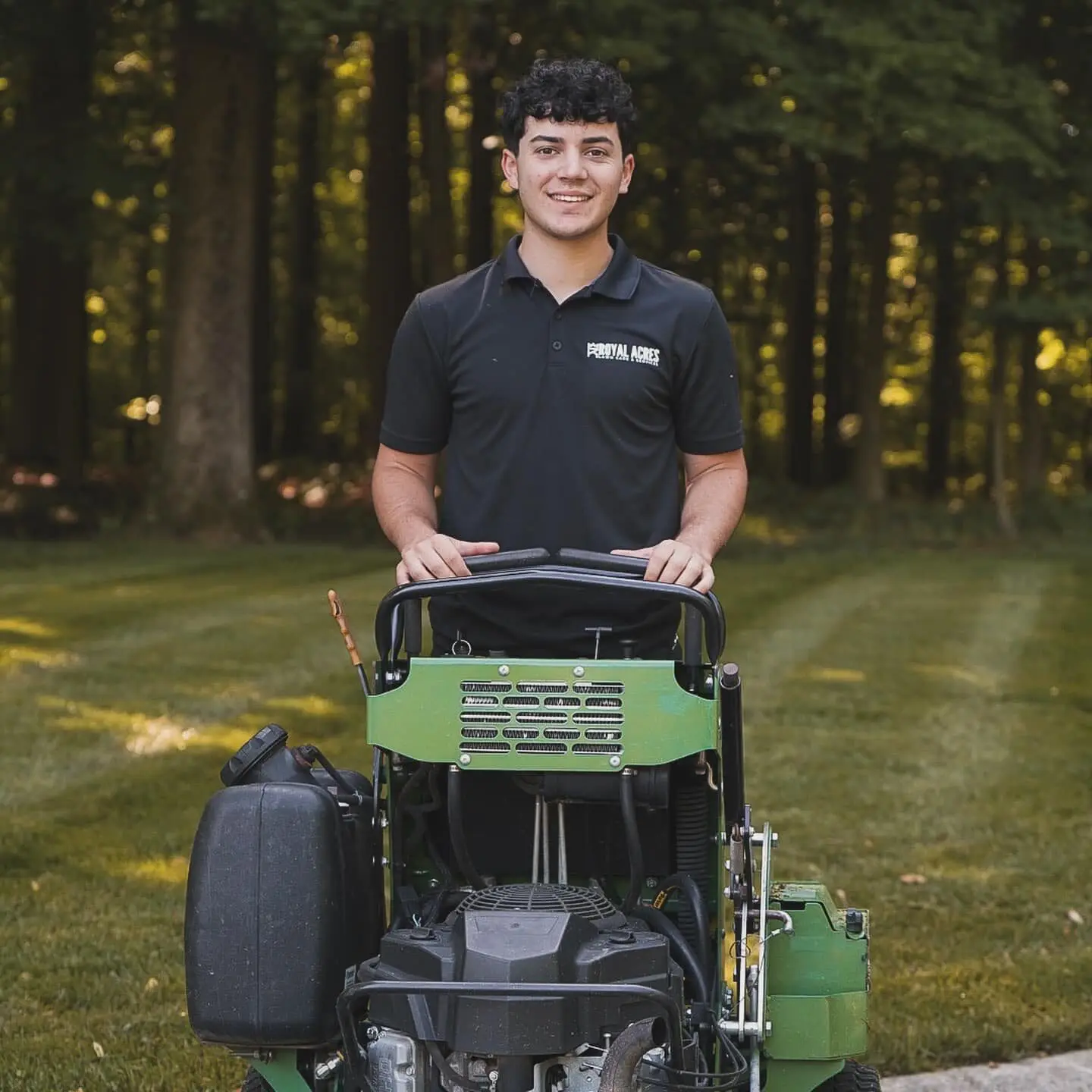 A smiling crew member on a stand-on mower