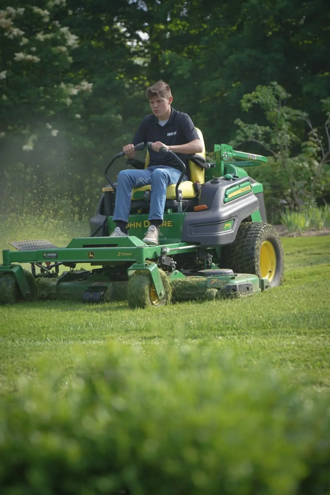 A crew member mowing on a zero-turn mower